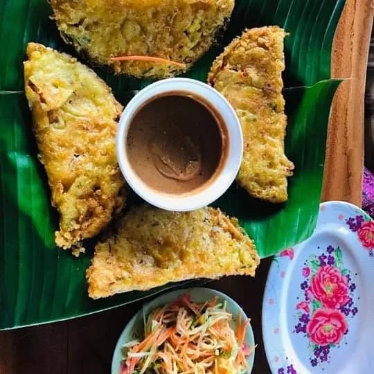 Banh xeo y los platos de hierbas que lo acompañan.