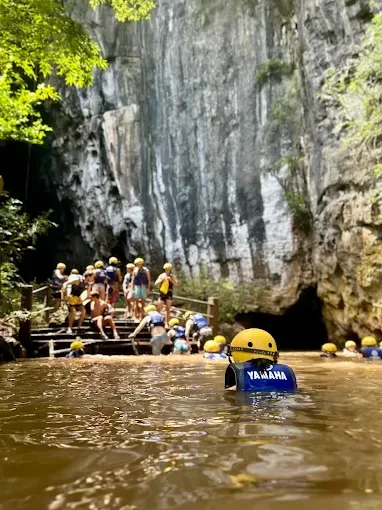 Swimmers in helmets and life jackets at the entrance to Dark Cave
