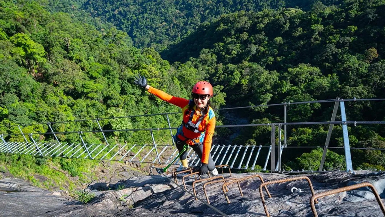 A climber on the suspension bridge above the jungle at Do Quyen