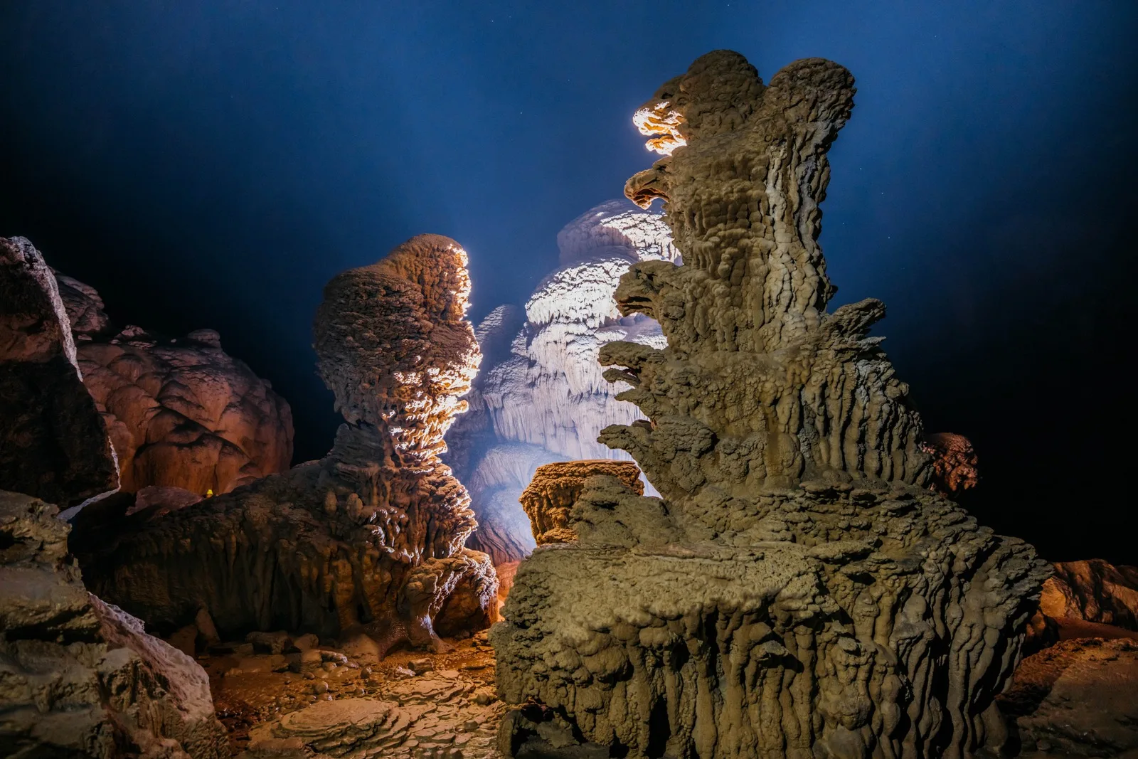 Stalagmite columns lit from below deep inside Hang Pygmy