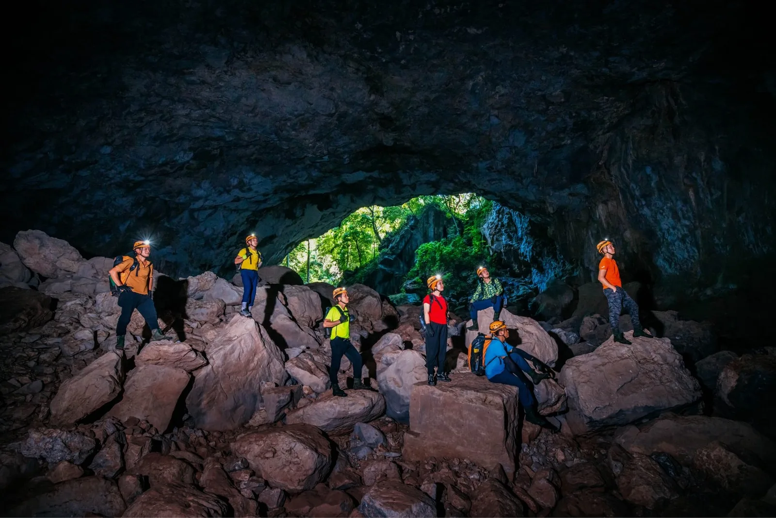 A group standing on boulders at the edge of the Kong Collapse sinkhole