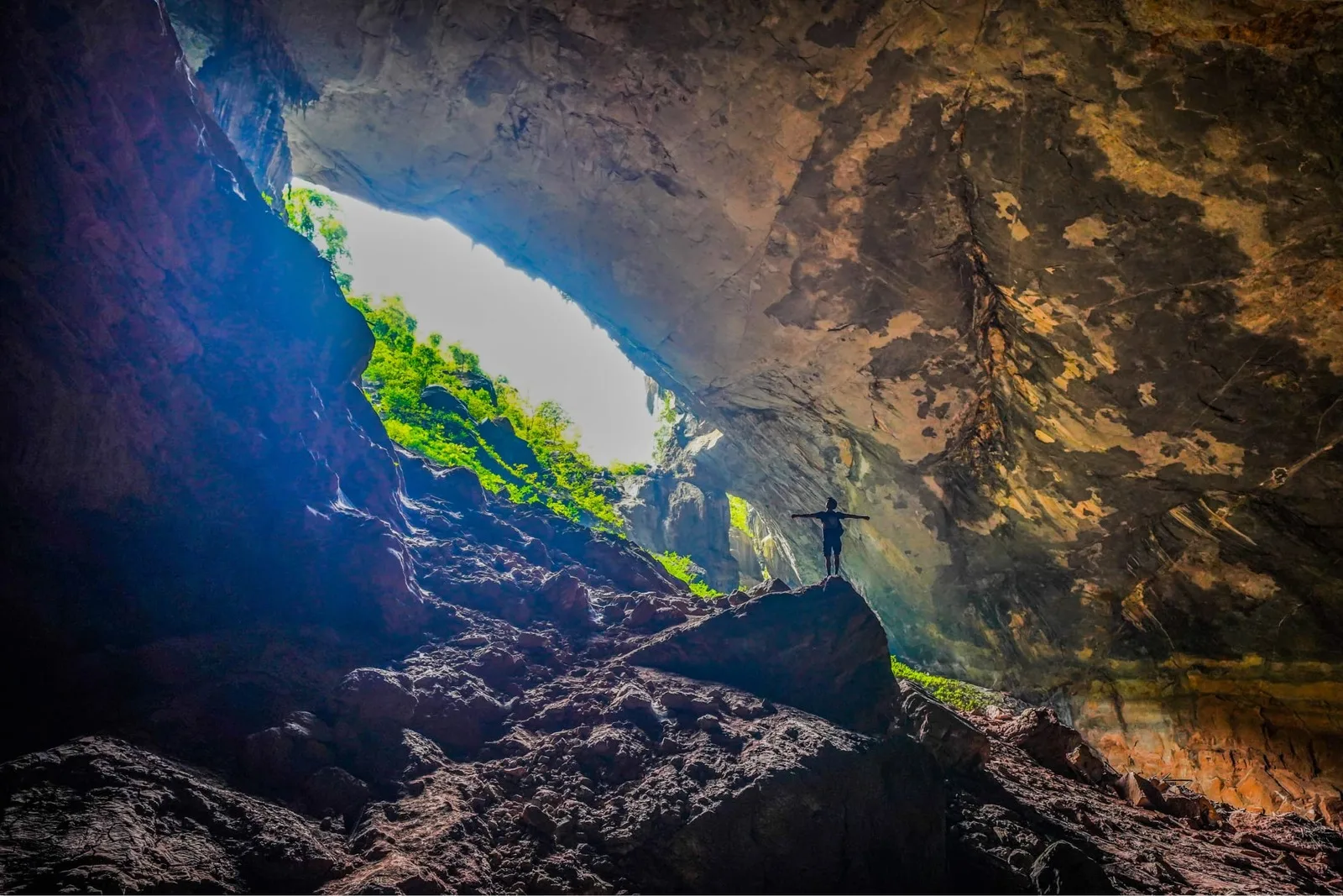 Daylight at the mouth of Tiger Cave with jungle growing on the rock